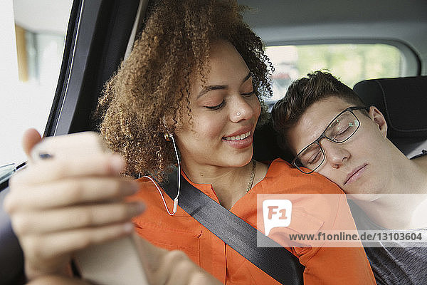 Junges Paar schläft und hört Musik im Auto