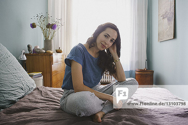 Portrait smiling woman sitting on bed