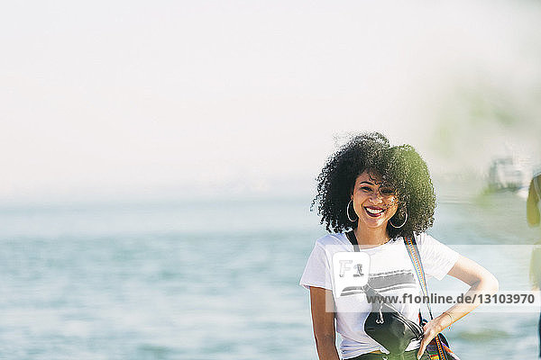 Porträt lächelnde junge Frau am Meeresufer