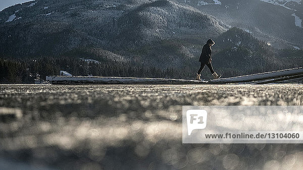 Frau in warmer Kleidung beim Spaziergang auf dem winterlichen Seedock  Whistler  British Columbia  Kanada