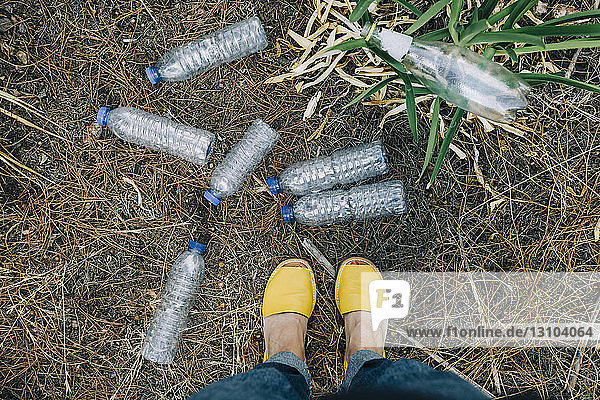 Persönliche Perspektive einer Frau  die vor weggeworfenen Plastikwasserflaschen steht