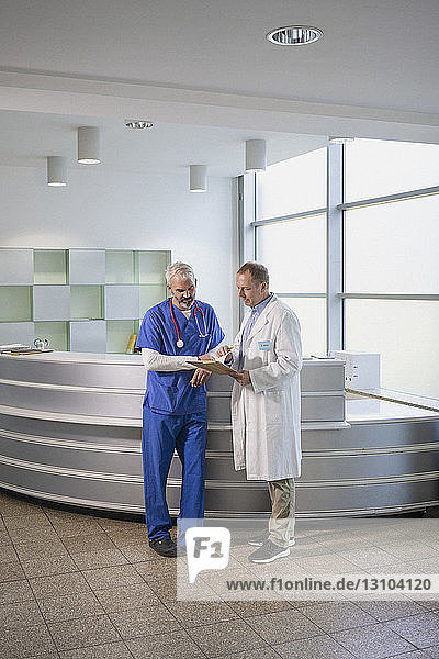 Male doctors discussing medical record in hospital