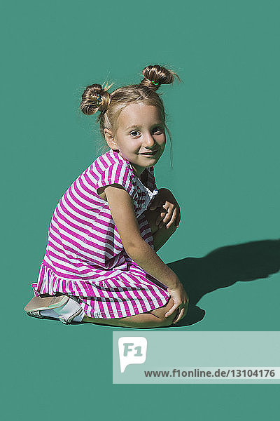 Portrait smiling girl against green background
