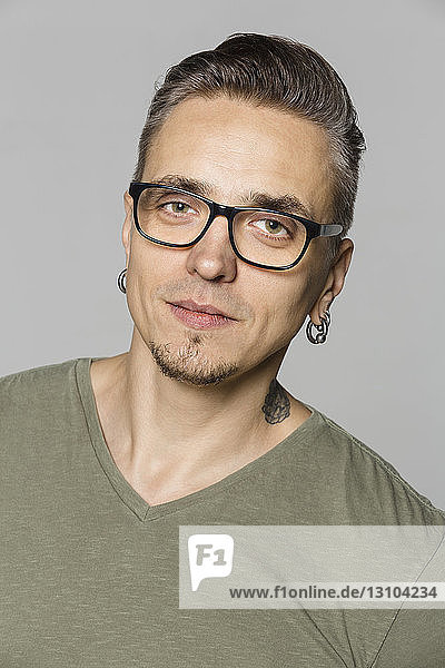 Portrait of man with glasses against gray background