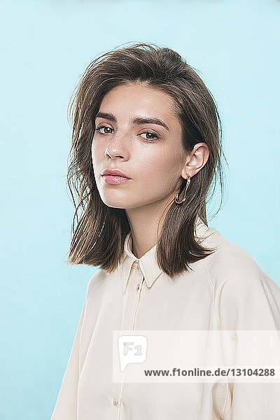 Portrait of female fashion model against blue background