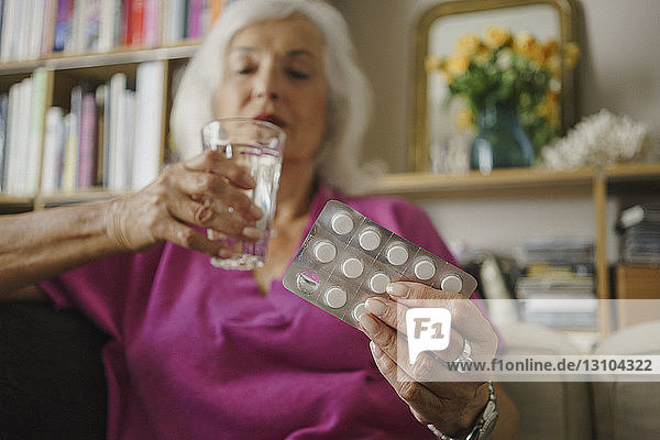 Ältere Frau nimmt Medikamente ein
