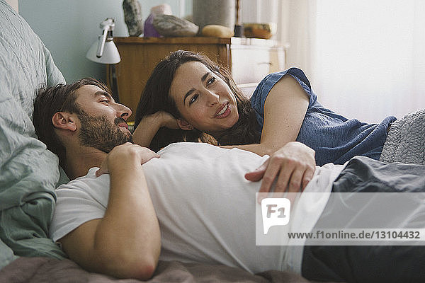 Couple relaxing and talking on bed