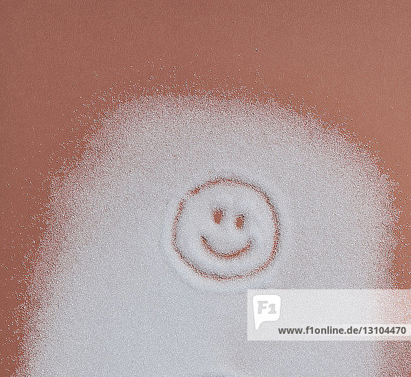 Smiley face in sugar on orange background