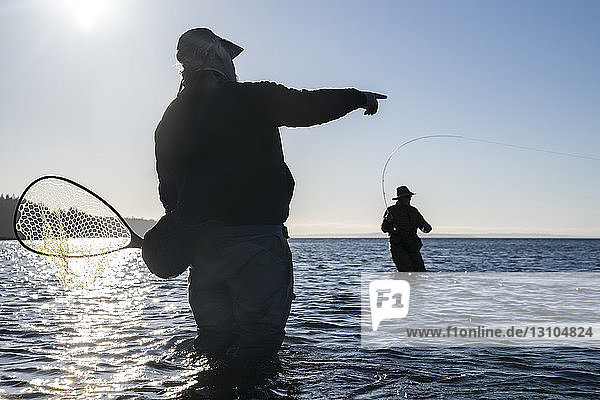 Ein Führer berät seinen Klienten beim Fliegenfischen im Salzwasser auf Meerforellen und Lachs im Nordwesten des Staates Washington  USA