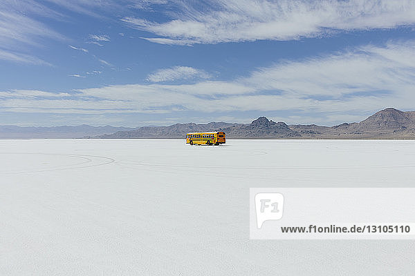Gelber Schulbus fährt auf Salt Flats