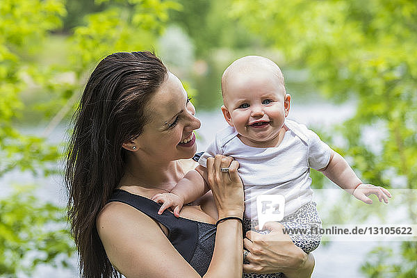 Porträt einer jungen Mutter  die im Sommer Zeit mit ihrer Tochter in einem Park verbringt  während ihr kleines Mädchen für die Kamera lächelt; Edmonton  Alberta  Kanada