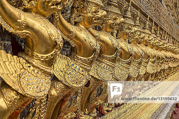 Goldene Skulpturen mythologischer Kreaturen an der Wand des Wat Phra Kaew; Bangkok  Thailand