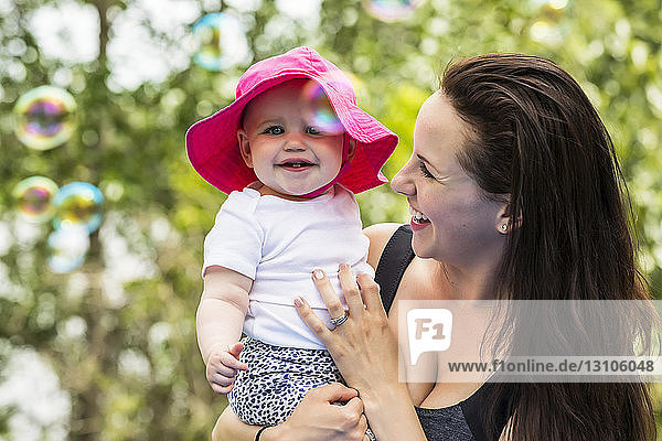 Eine junge Mutter verbringt im Sommer viel Zeit mit ihrer Tochter in einem Park und beobachtet die Blasen in der Luft; Edmonton  Alberta  Kanada