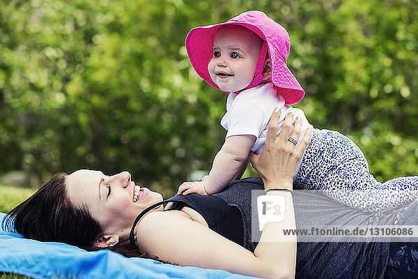 Eine junge Mutter verbringt an einem warmen Sommertag viel Zeit mit ihrer kleinen Tochter in einem Park; Edmonton  Alberta  Kanada