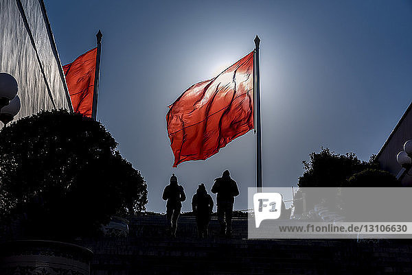Silhouetten von Menschen und Flagge auf dem Platz des Himmlischen Friedens; Peking  China