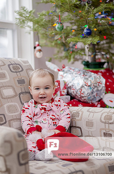 Porträt eines Kleinkindes in seinem festlichen Weihnachtspyjama vor dem Weihnachtsbaum; Langford  British Columbia  Kanada