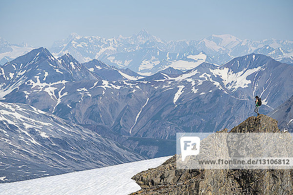 Woman enjoying an afternoon amongst the mountains and glaciers of Kluane National Park and Reserve; Haines Junction  Yukon  Canada
