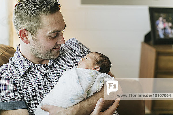 Porträt eines Vaters  der sein neugeborenes Baby im Arm hält; Surrey  British Columbia  Kanada