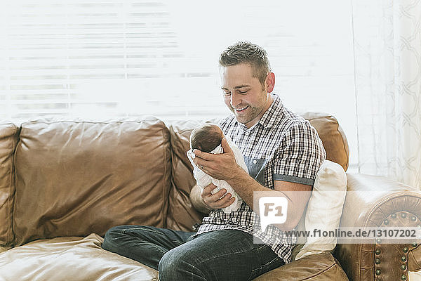Porträt eines Vaters  der sein neugeborenes Baby im Arm hält; Surrey  British Columbia  Kanada
