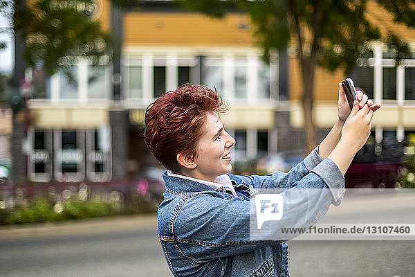 A teenage girl with red hair taking a self-portrait with a smart phone; Abbotsford  British Columbia  Canada
