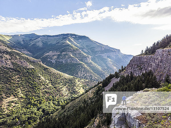 Ein Mann steht auf einem Bergrücken und blickt auf die Berge und Täler unter ihm; Logan  Utah  Vereinigte Staaten von Amerika