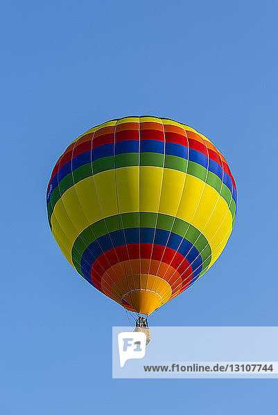 Low angle view of a colourful hot air balloon in a blue sky; St. Jean sur Richelieu Quebec Canada