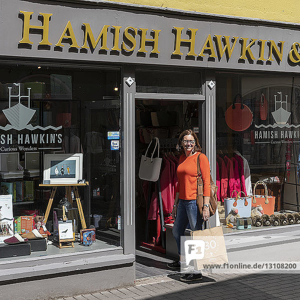 Touristin beim Einkaufen und beim Posieren für die Kamera; Kinsdale  Grafschaft Cork  Irland