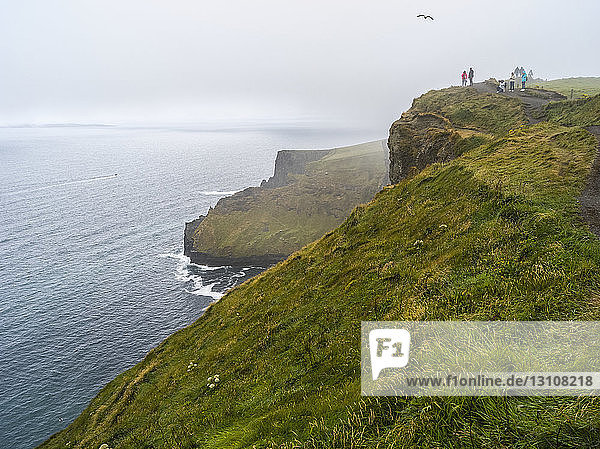 Tourists at the Cliffs of Moher along the Atlantic Ocean; Ennistymon  County Galway  Ireland