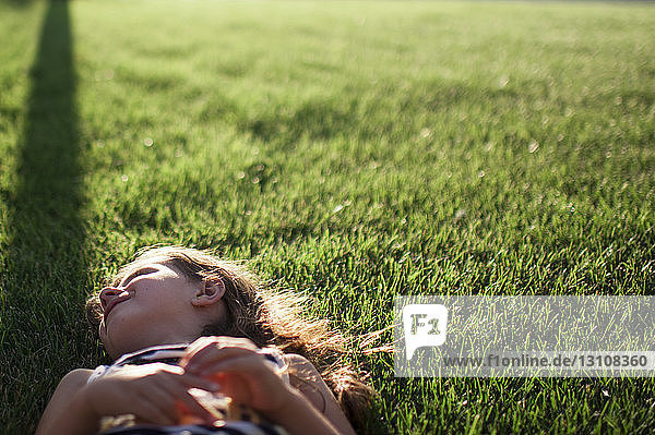 Lächelndes Mädchen auf Grasfeld liegend