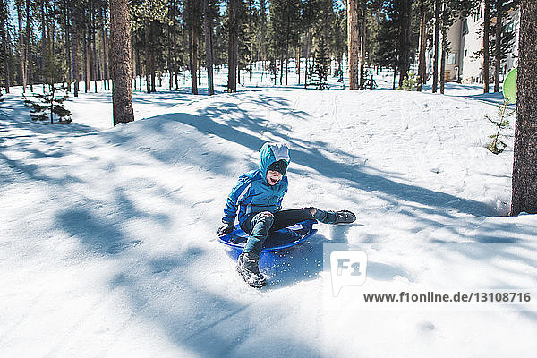 High angle view of girl in sledge sliding at snow covered field