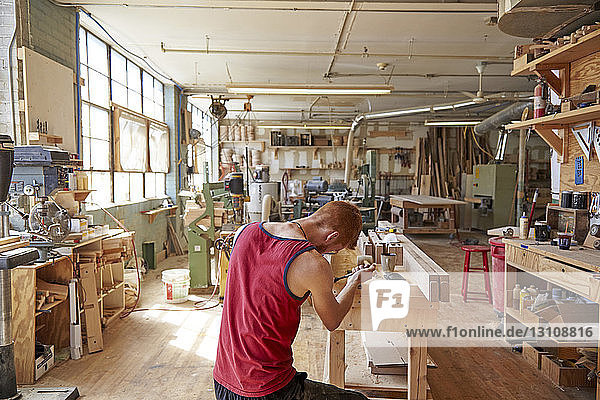 Rear view of carpenter working in workshop