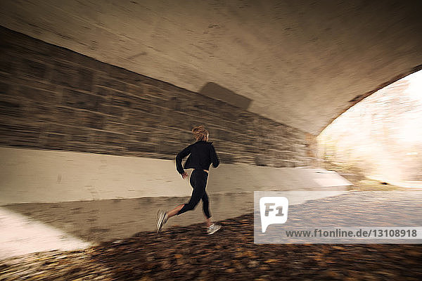 Frau joggt im alten Tunnel