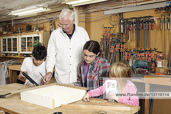 Zimmermann unterrichtet Studenten in einer Werkstatt