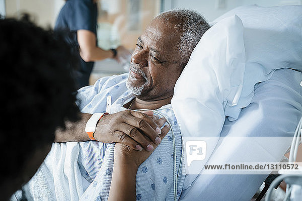 Vater tröstet Tochter  während Ärztin im Hintergrund arbeitet