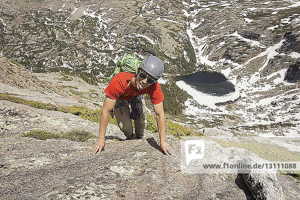 High angle portrait of hiker climbing on rock