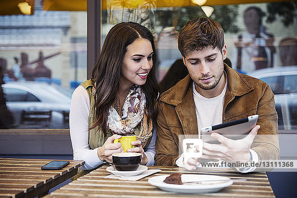 Paar benutzt einen Tablet-Computer  während es im Café sitzt