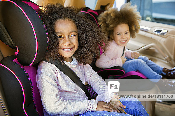Porträt von lächelnden Schwestern im Auto sitzend