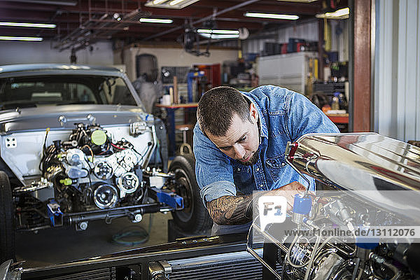 Mechaniker repariert Automotor in Autowerkstatt