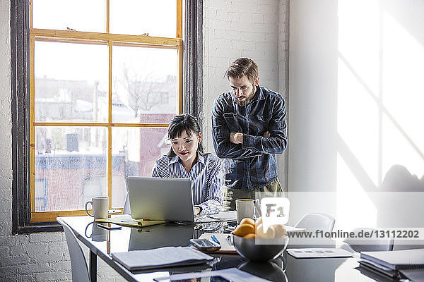 Geschäftsleute schauen auf den Laptop  während sie im Kreativbüro arbeiten