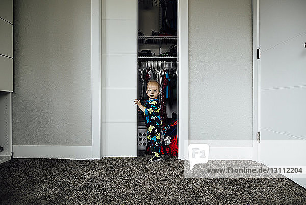 Porträt eines kleinen Jungen am Schrank stehend