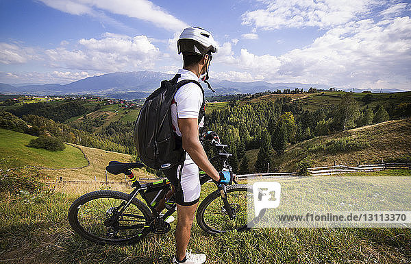 Side view of athlete with bicycle on mountain