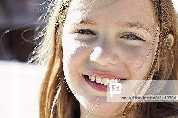 Porträt eines lächelnden Mädchens an einem sonnigen Tag