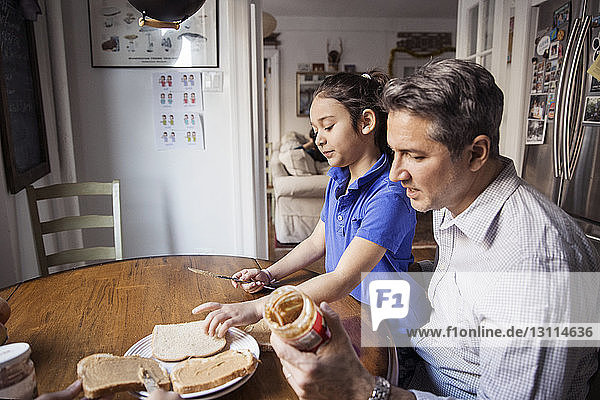 Vater und Tochter bereiten zu Hause das Frühstück in der Küche vor