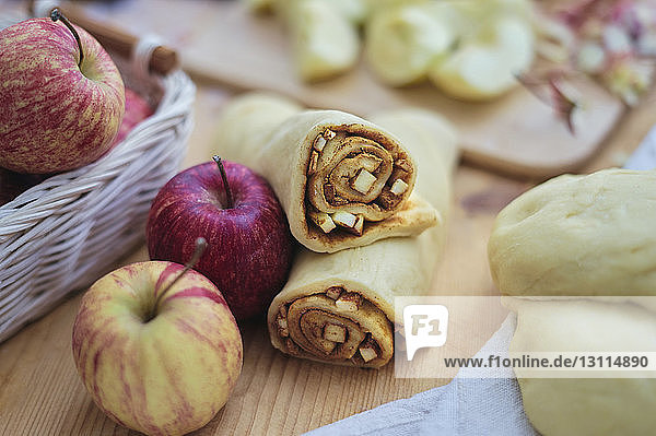 Nahaufnahme von Apfelscheiben und gemahlenem Zimt in Blätterteig gerollt auf der Küchentheke