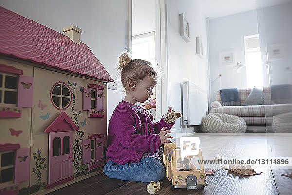 Side view of girl playing with toys at home
