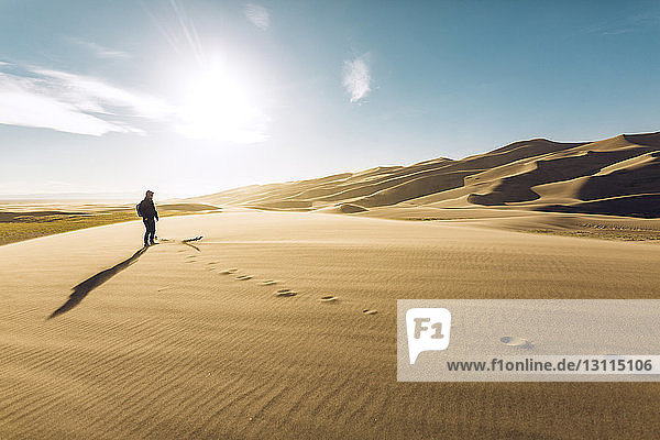 Hiker on sand at Great Sand Dunes National Park during sunny day