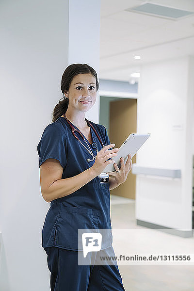 Porträt einer selbstbewussten Ärztin mit Tablet-Computer im Krankenhaus
