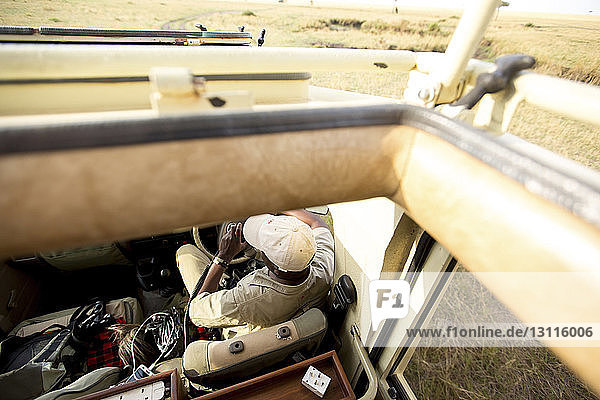 Hochwinkelaufnahme eines Mannes im Geländewagen im Serengeti-Nationalpark