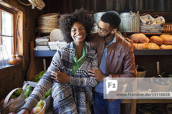 Cheerful couple standing in organic shop