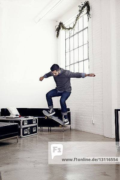 Businessman skateboarding in creative office